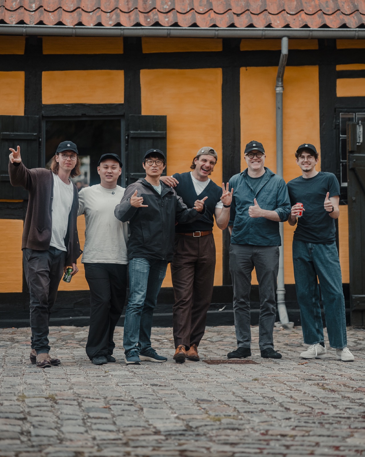 Attendees posing together in Cursor caps outside the venue