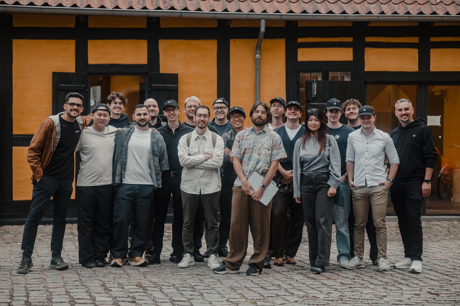 Sixteen competitors posing together outdoors